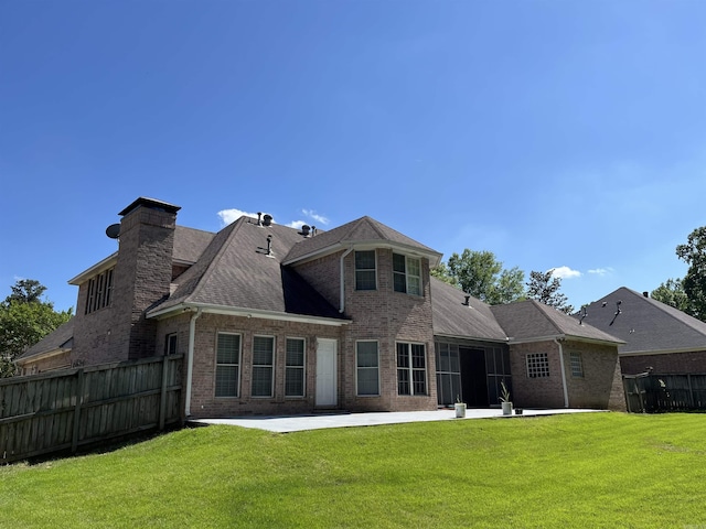 rear view of property featuring a lawn