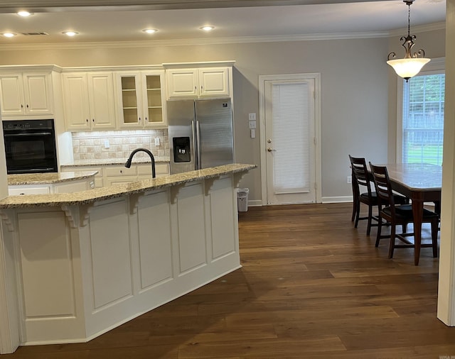 kitchen with black oven, stainless steel fridge, white cabinets, and light stone counters