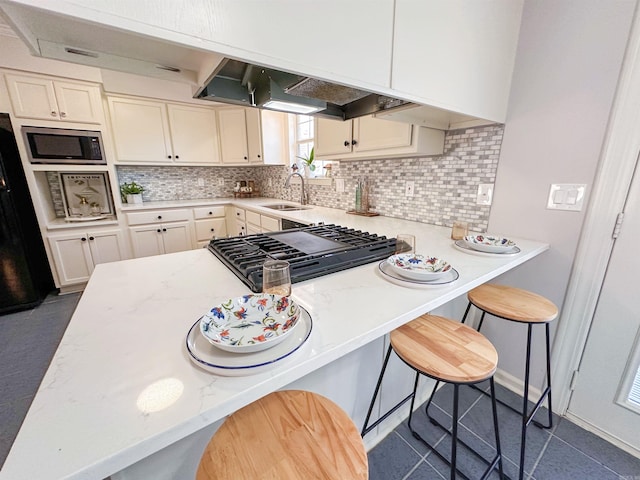 kitchen with a breakfast bar, decorative backsplash, stainless steel appliances, and sink