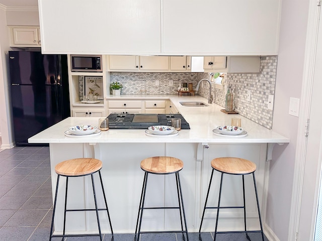 kitchen with backsplash, a kitchen breakfast bar, crown molding, sink, and appliances with stainless steel finishes