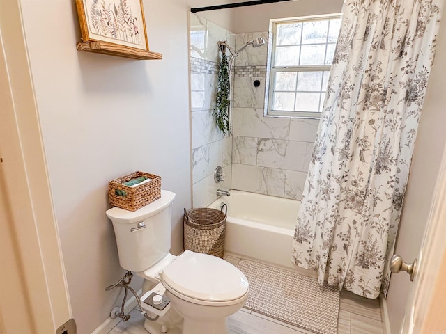 bathroom featuring shower / bath combination with curtain and toilet