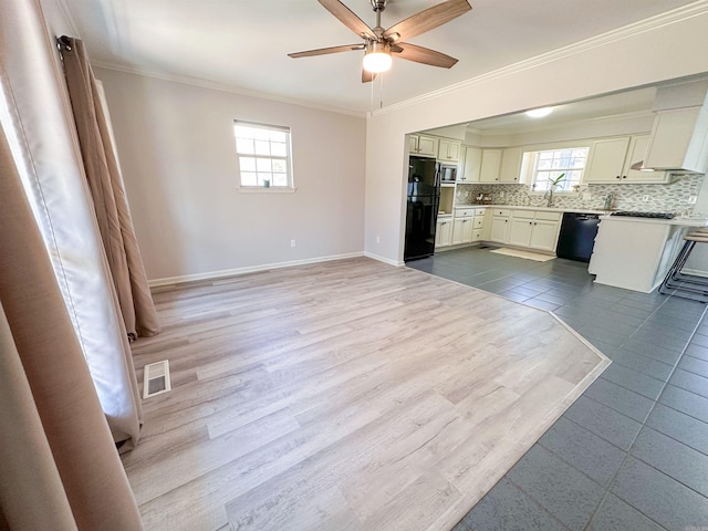 kitchen featuring ceiling fan, tasteful backsplash, white cabinets, black appliances, and ornamental molding