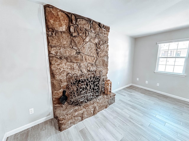 living room featuring a stone fireplace and light hardwood / wood-style flooring