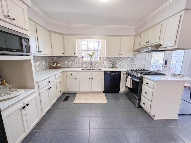 kitchen with kitchen peninsula, decorative backsplash, stainless steel appliances, sink, and white cabinetry