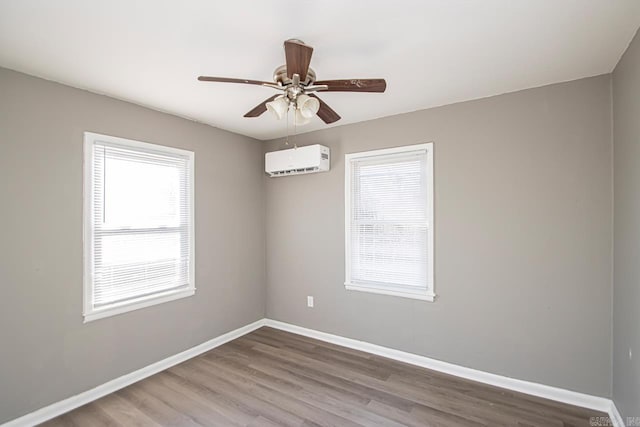 unfurnished room featuring an AC wall unit, ceiling fan, and wood-type flooring