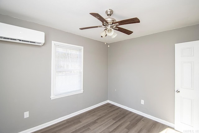 empty room with ceiling fan, wood-type flooring, and a wall mounted air conditioner