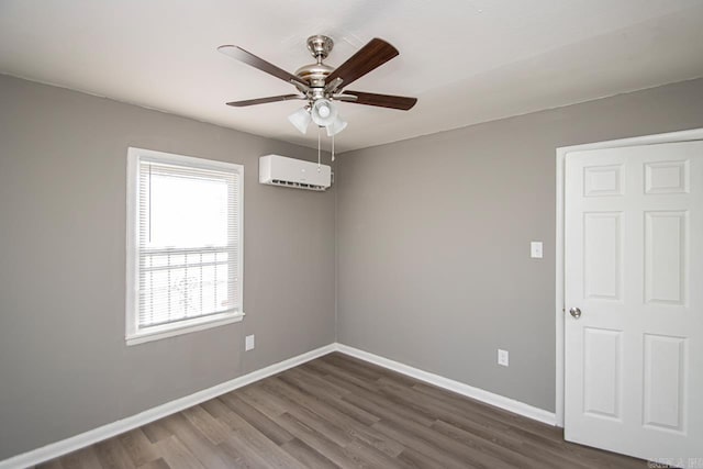 unfurnished room with a wall mounted air conditioner, ceiling fan, and dark wood-type flooring