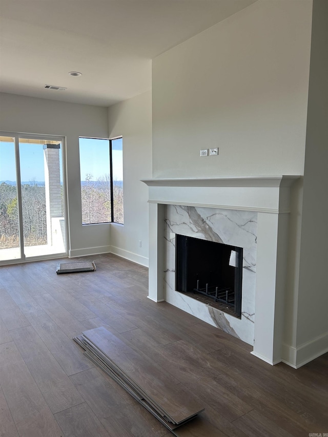 unfurnished living room with hardwood / wood-style flooring and a premium fireplace