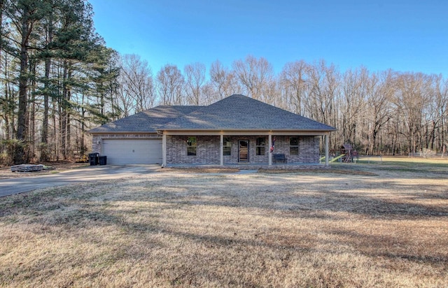 view of front of home featuring a porch, a garage, and a front yard