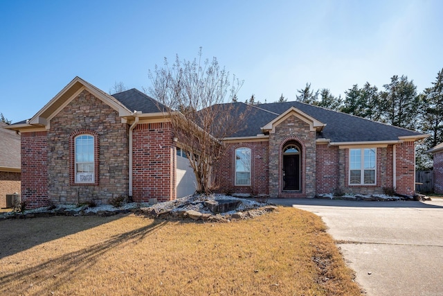 view of front of property with a front yard, central AC, and a garage