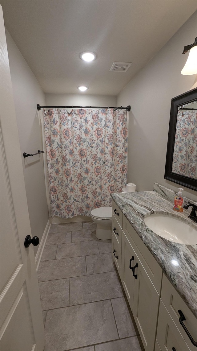 bathroom featuring vanity, walk in shower, and toilet