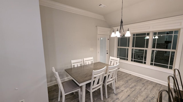 unfurnished dining area featuring ornamental molding, wood-type flooring, a chandelier, and lofted ceiling