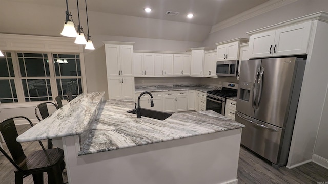 kitchen with sink, white cabinetry, hanging light fixtures, a kitchen breakfast bar, and stainless steel appliances