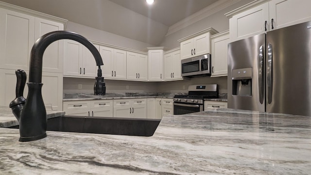 kitchen featuring white cabinetry, light stone counters, and stainless steel appliances