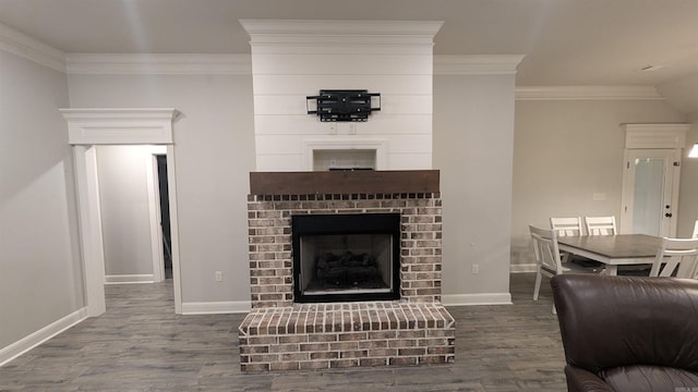 living room with crown molding, a brick fireplace, and wood-type flooring