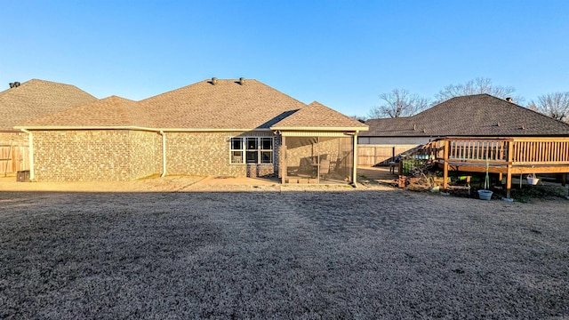 rear view of house with a wooden deck and a sunroom