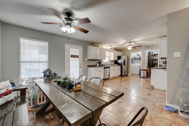 dining space with washer / clothes dryer, ceiling fan, and light tile patterned flooring