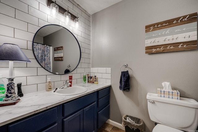 bathroom with tasteful backsplash, vanity, and toilet