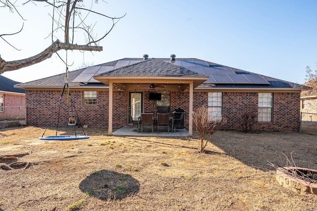 rear view of house featuring solar panels and a patio