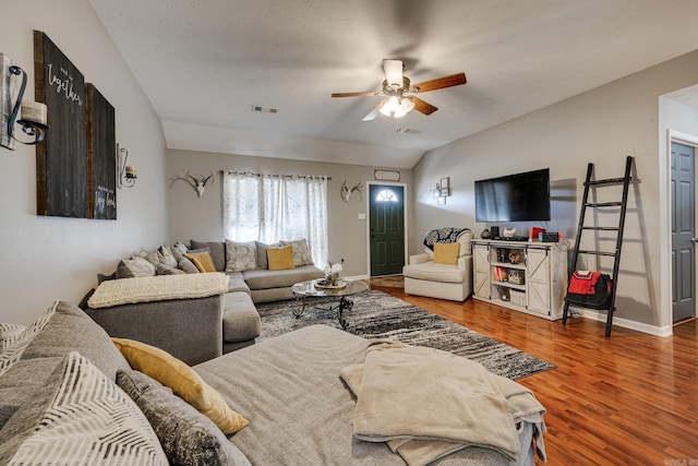 living room with hardwood / wood-style flooring, ceiling fan, lofted ceiling, and a textured ceiling