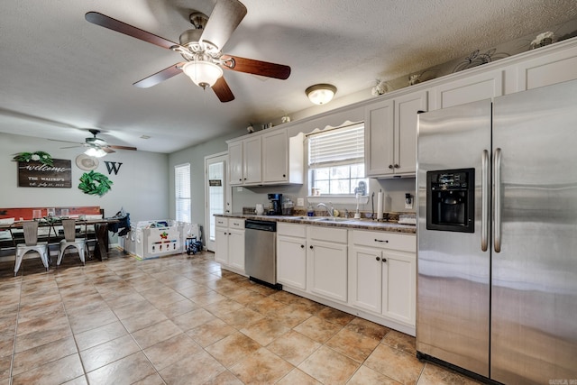 kitchen with white cabinets, appliances with stainless steel finishes, a textured ceiling, and sink