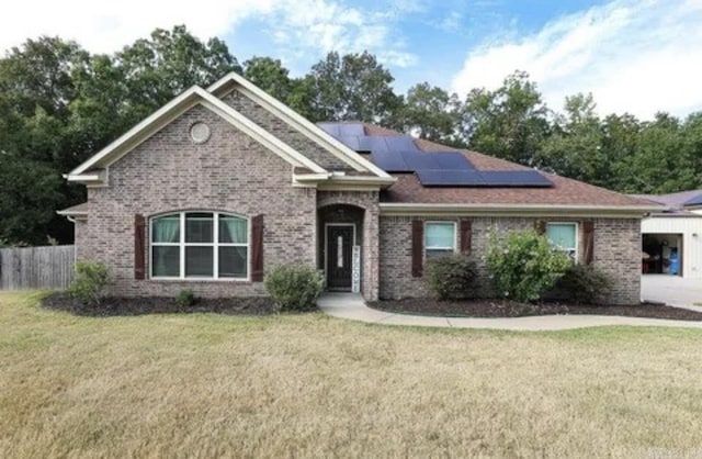 view of front facade featuring a front lawn and solar panels