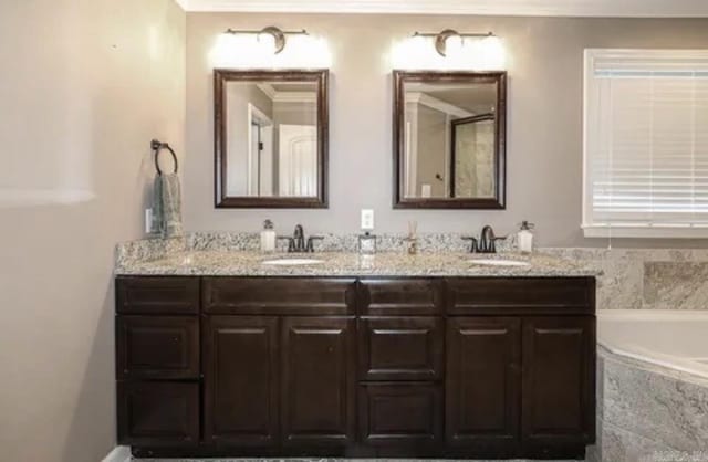 bathroom featuring tiled tub and vanity