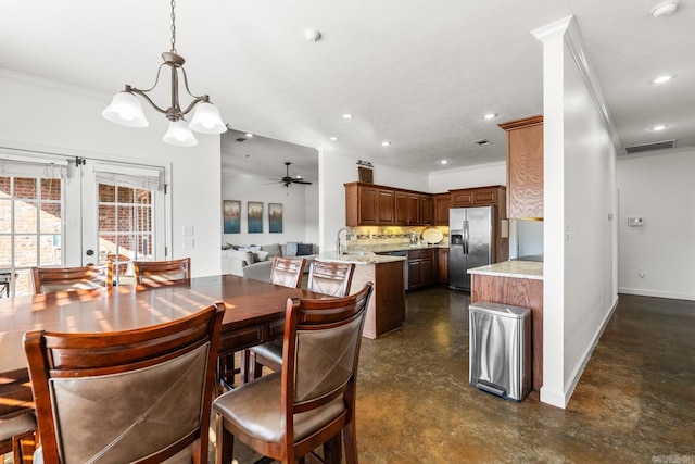 dining room featuring french doors, crown molding, sink, and ceiling fan with notable chandelier