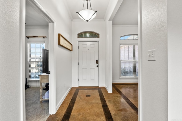 foyer with dark tile patterned floors and ornamental molding