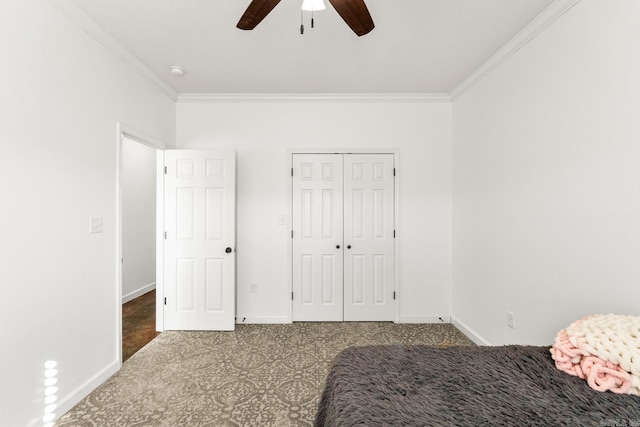 carpeted bedroom with ceiling fan, crown molding, and a closet