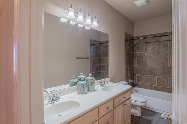 full bathroom featuring tile patterned flooring, vanity, toilet, and tiled shower / bath combo