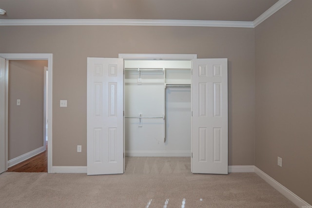 unfurnished bedroom with carpet floors, a closet, and ornamental molding