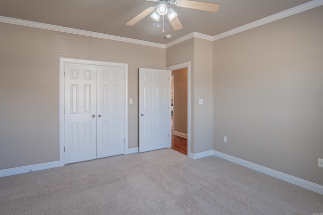 unfurnished bedroom featuring ceiling fan, light colored carpet, crown molding, and a closet