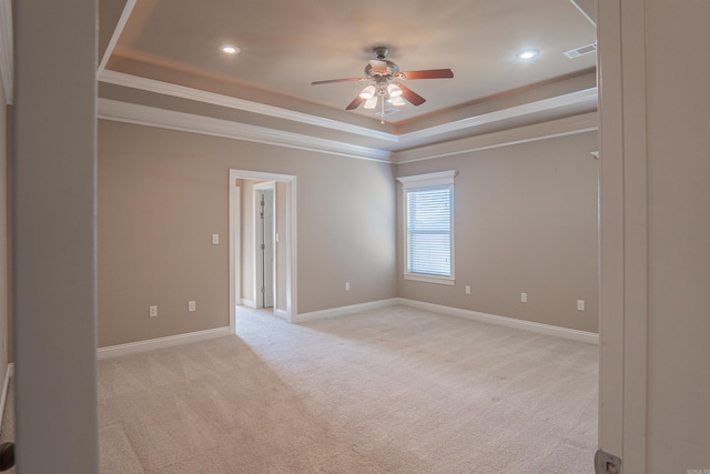 unfurnished room with ornamental molding, a tray ceiling, ceiling fan, and light colored carpet