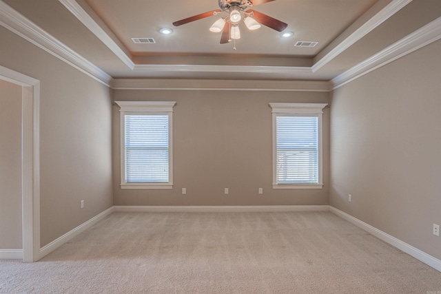 unfurnished room featuring light colored carpet, crown molding, and a tray ceiling