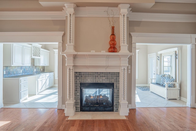 unfurnished living room featuring a fireplace, light hardwood / wood-style floors, and crown molding