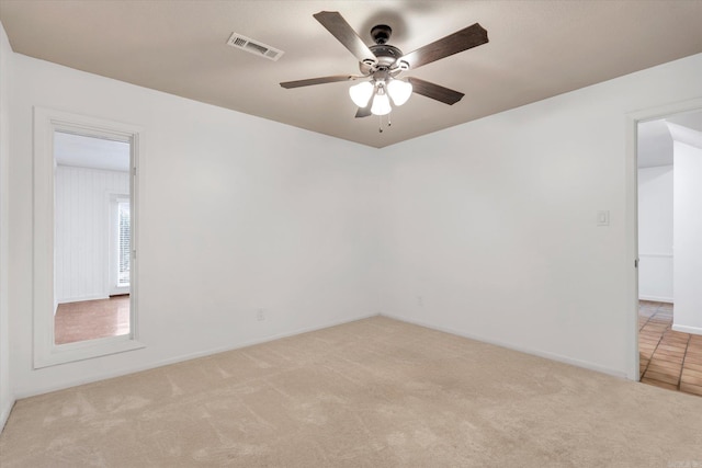 empty room with a ceiling fan, carpet, visible vents, and baseboards