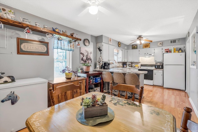 dining area featuring ceiling fan and light wood-type flooring