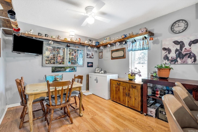 dining room featuring ceiling fan, a textured ceiling, and light wood-type flooring