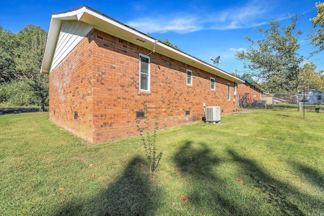 view of property exterior with central air condition unit and a yard