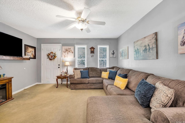 carpeted living room featuring ceiling fan and a textured ceiling