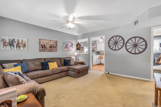 living room featuring a textured ceiling, ceiling fan, and light carpet