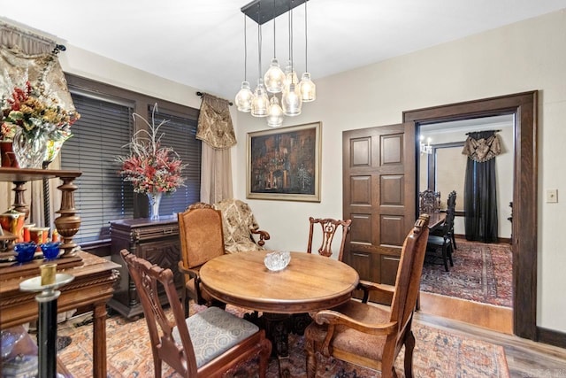 dining room featuring wood-type flooring and an inviting chandelier