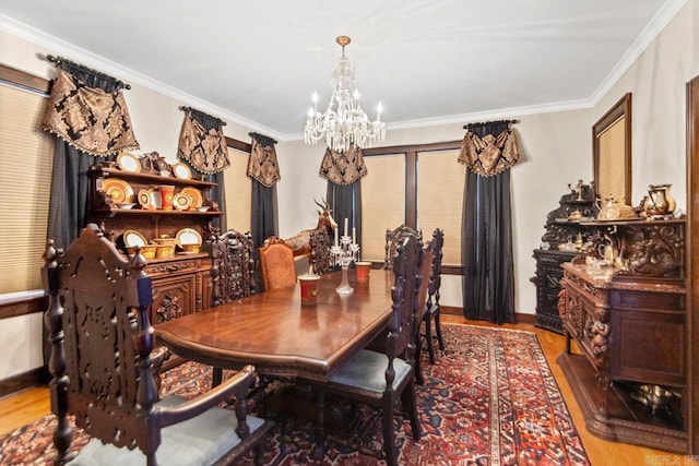 dining room with light hardwood / wood-style floors, ornamental molding, and an inviting chandelier