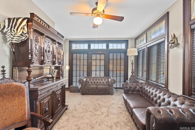 living area featuring light carpet and ceiling fan