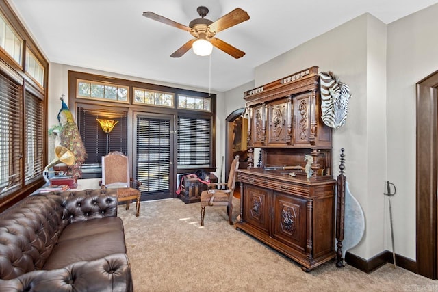 carpeted living room with ceiling fan