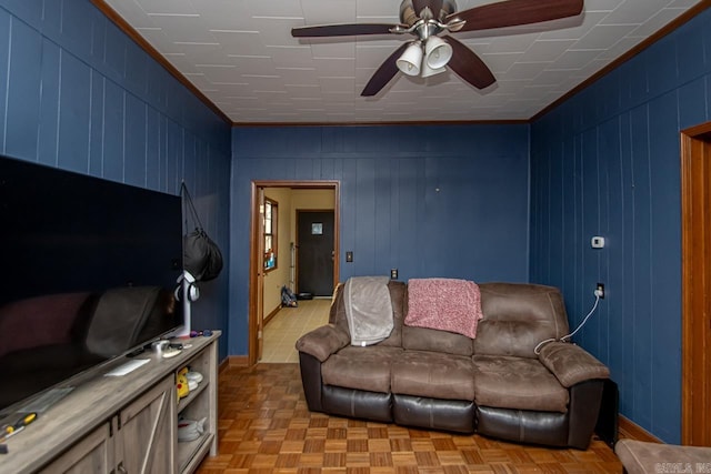 living room with crown molding, wooden walls, and light parquet floors