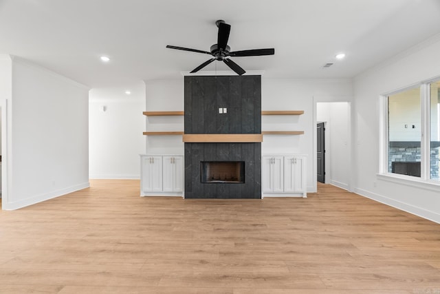 unfurnished living room featuring a fireplace, light wood-type flooring, ceiling fan, and crown molding