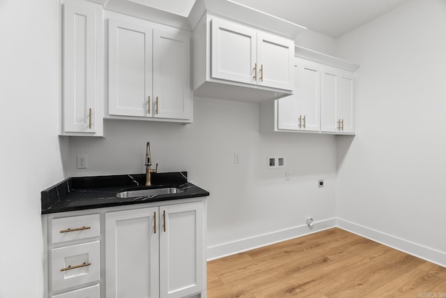 washroom featuring sink, cabinets, washer hookup, electric dryer hookup, and light hardwood / wood-style flooring