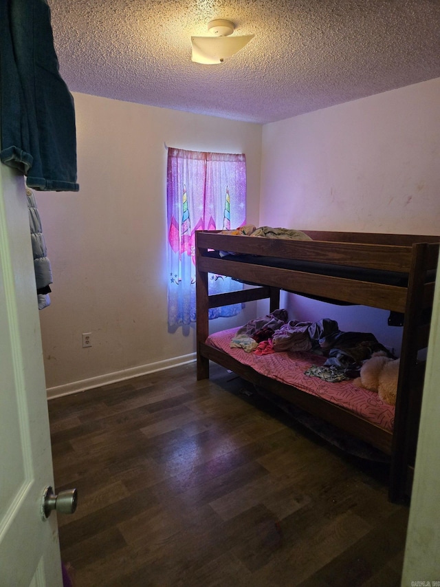 bedroom featuring dark hardwood / wood-style flooring and a textured ceiling